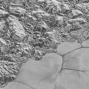 Mountains of ice along a portion of smoother ice planes on Pluto’s surface.